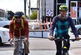 Mitch Underhay, left, and Isaac Williams ride their bikes on Victoria Row. The two members of Bike Friendly Charlottetown want to see e-bikes safely integrated into the existing Island cycling community.