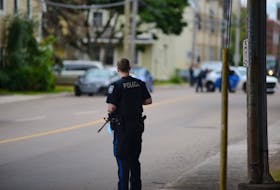A Charlottetown police officer stands watch during an armed standoff with a man who barricaded himself inside a building on Euston Street on Aug. 21, 2020.