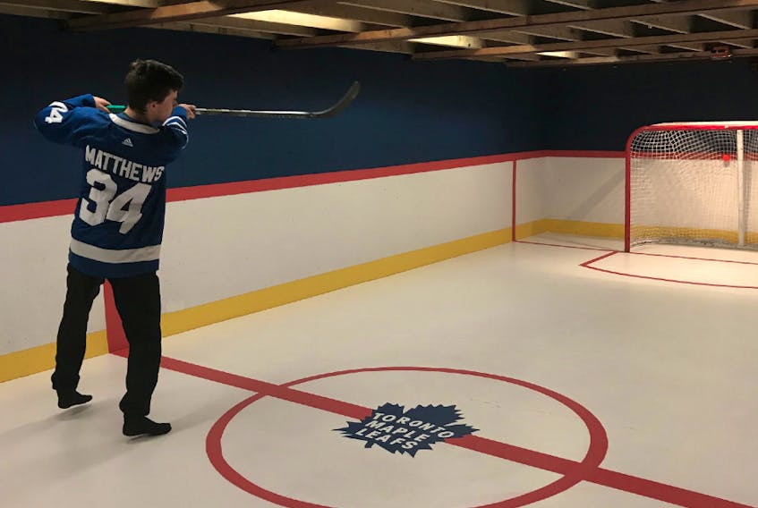Jonah MacMillan of Clyde River, a Toronto Maple Leafs’ superfan, takes a shot on net in his parents’ basement, which he turned into a hockey rink last October. In case it wasn’t obvious, Austin Matthews is his favourite player.