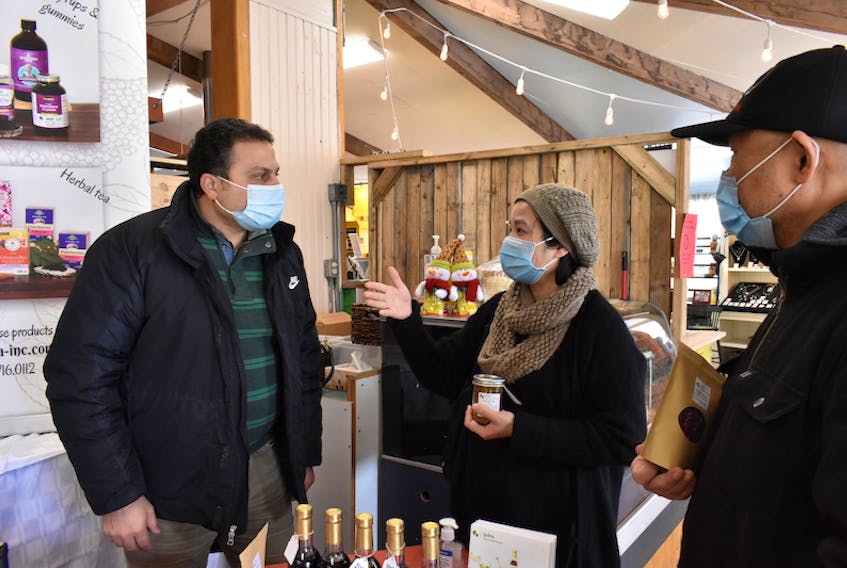 Lily Tran, middle, stops to talk with ElHosseiny ElSherif, left, and James Bunda at the Charlottetown Farmers' Market on Jan. 9.