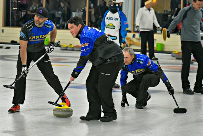 Michael Spencer, left, and Johnathan Greenan prepare to sweep a shot released by Terry Arsenault during the Island Petroleum cashspiel in Summerside over the weekend.
