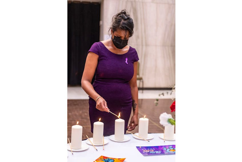 Debbie Langston, chairperson of the P.E.I. Advisory Council on the Status of Women, lights a candle in memory of victims of gender-based violence at a Montreal Massacre commemoration ceremony in December 2020.