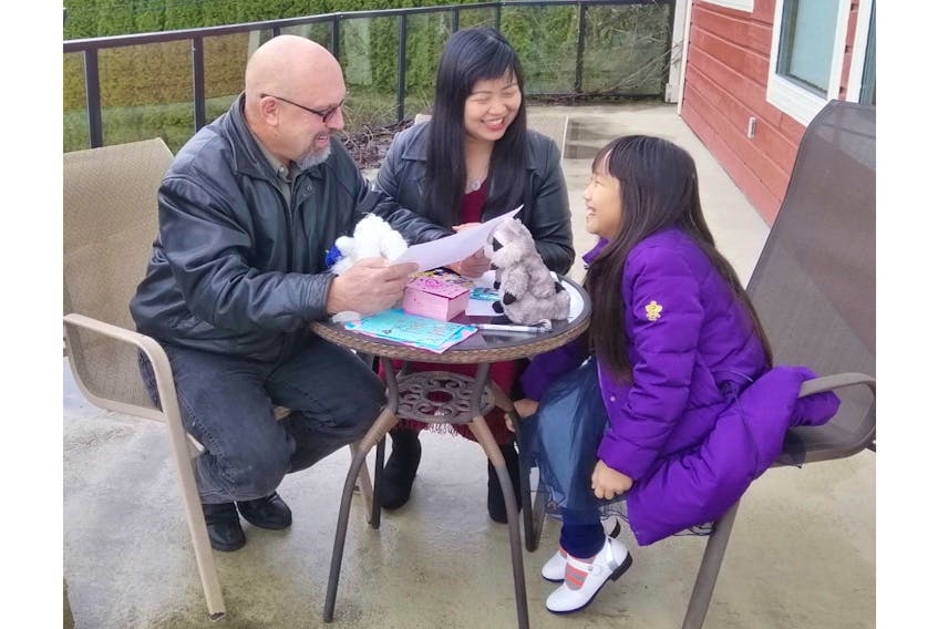 Montague native Monte Gisborne spends some time earlier with his wife, Daniela, centre, and his stepdaughter, Dominica, on the patio of their home in Coquitlam, B.C.