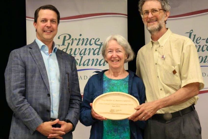 Environment, Water and Climate Change Minister Brad Trivers, left, congratulates Marion Copleston and Tony Reddin, who received P.E.I. Environmental Awards in the individual category.