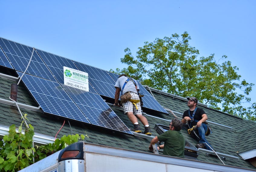 A crew from Renewable Lifestyles install solar panels on the roof of Tim McCullough's Charlottetown home on Aug. 13. The panels are the final piece in McCullough's energy-efficient renovations.