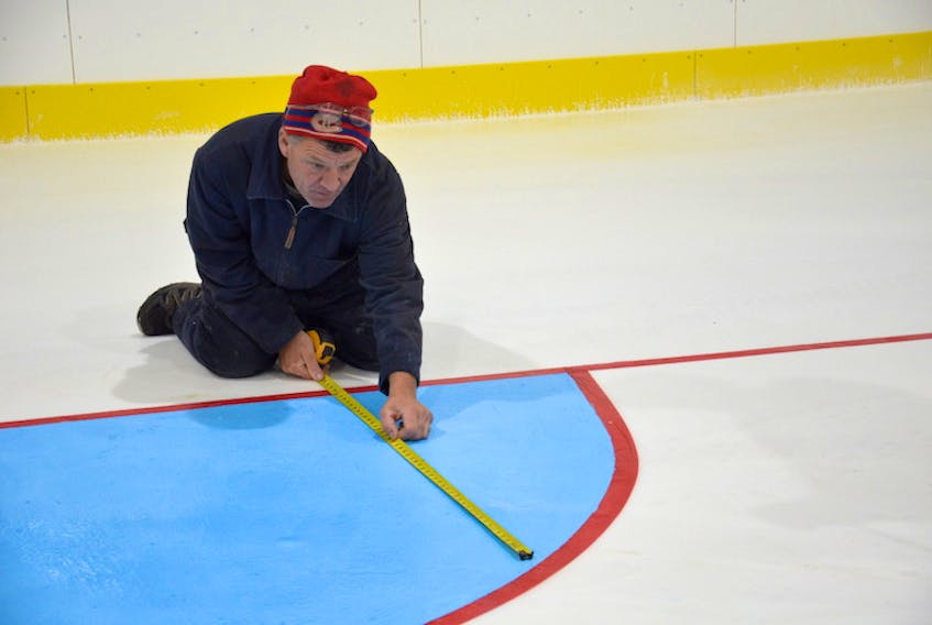 Raymond Gallant measures a goal crease at the O’Leary Community Sports Centre. Gallant, a former ice-maker at the arena, took a week’s holidays to volunteer his time to oversee the installation of the ice for the 2020-21 season while the facility looks for a new ice-maker.