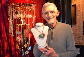 Ricky Lee shows a dragon’s eye pendant he made out of an oval of clear glass, painted in layers, to give a three-dimensional effect. It’s one of the pieces on display at the Manse at 14155 St. Peters Rd., Marshfield.
