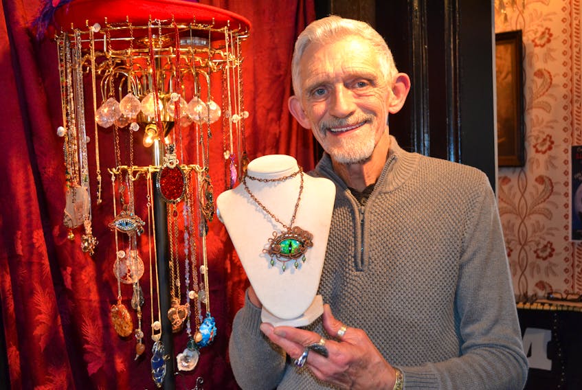 Ricky Lee shows a dragon’s eye pendant he made out of an oval of clear glass, painted in layers, to give a three-dimensional effect. It’s one of the pieces on display at the Manse at 14155 St. Peters Rd., Marshfield.