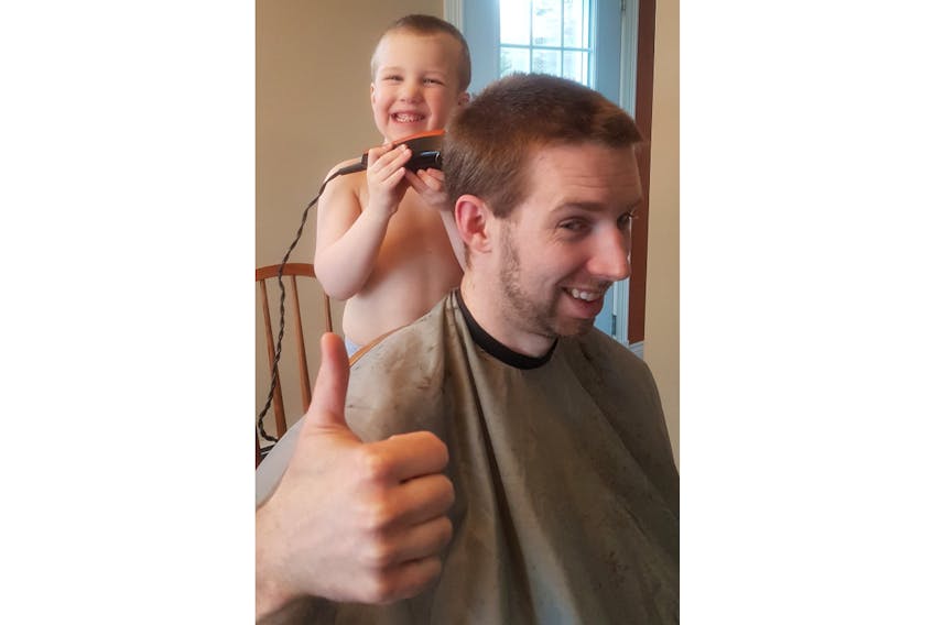 A lot of Islanders have turned into barbers these past few weeks. Here, Owen Larter, 4, of Hampshire gives his father, Brodie, a buzz cut.