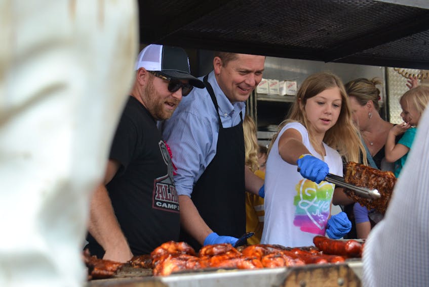 Andrew Scheer, centre, and his daughter Grace dish out some ribs at the Summerside Ribfest on Friday. Scheer is on P.E.I. Friday and Saturday.