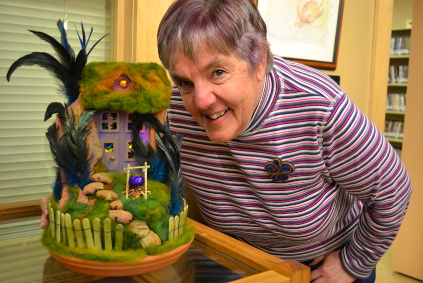 Joyce Gill shows her creation, “Haunted House”. The installation is made from fibres, feathers and paint.  - Sally Cole