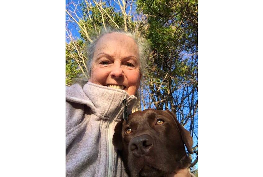 Jean McCardle of Victoria-by-the-Sea poses with her chocolate lab, Clover, during a walk in Tryon Monday. McCardle is grateful to mountain bikers coming to her aid when she got lost walking her dog on the cross-country trails at Mark Arenza Provincial Ski Park last month.