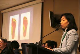 Nancy Wu, whose daughter enrolled at Moonlight International Academy, shows a slide indicating that she and her daughter were flat-footed. Wu said the issue was raised to her by nuns at the academy, and was evidence of the care shown to children by teachers at the Buddhist school.
Stu Neatby/THE GUARDIAN
