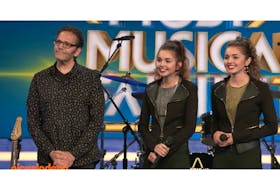 David Rashed listens to feedback from the judges with his two daughters, Lily, centre, and Ava following their performance on the U.S. reality show “America’s Most Musical Family’’ on Dec. 13. It was the second week in a row the twins appeared on the program but they were eliminated in the broadcast.