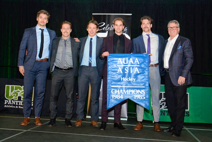 Doug Currie presented the UPEI Panthers leadership group with the 1984-85 Atlantic hockey banner on Thursday. From left are Filip Rydstrom, Chad Labelle, Owen Headrick, Kameron Kielly, Tanner McCabe and Currie.