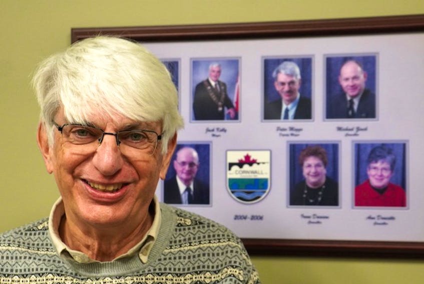 Cornwall councillor Peter Meggs stands by his 2004-2006 council photo (on the top, second from the right) at the town's hall on Jan. 20. Meggs will be resigning on Jan. 27.