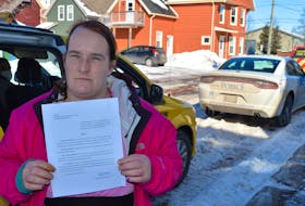 Lisa Hughes holds an eviction notice that said she must vacate her apartment on Richmond Street on Friday. Hughes received the notice on Thursday.