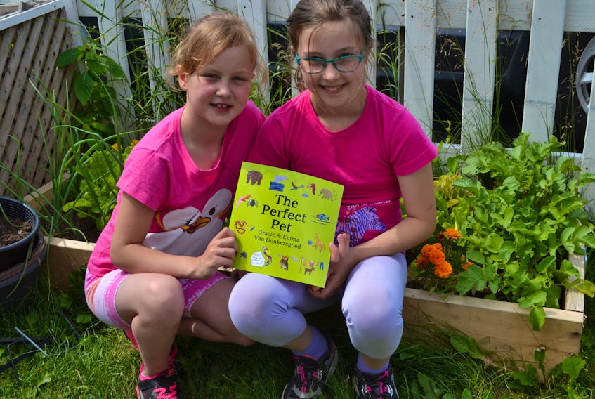 Emma Van Donkersgoed, 8, left, and Gracie Van Donkersgoed, 10, show “The Perfect Pet”, the book they co-wrote, which will be launched Saturday, July 20,10 a.m., at Nabuurs Gardens in Montague, starting at 10 a.m.