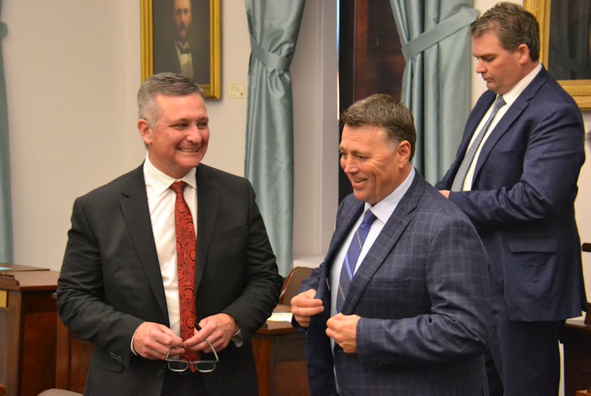 Premier Dennis King jokes with former finance minister Heath MacDonald before question period last week. King introduced a bill that will create an independent child and youth advocate on Tuesday.