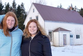 Chloe Loane, left, and her sister, Molly, stand outside Heatherdale's hall. A community non-profit organization recently took ownership of the hall.