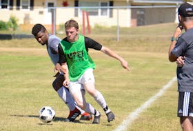 Chukwuka Chibuzo, left, and Kyle Connell battle for the ball along the sidelines in front of the UPEI Panthers men’s soccer coaching staff Saturday at Simmons soccer field in Charlottetown.