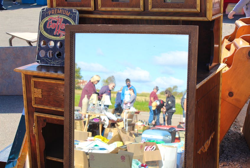The reflection in a mirror leaning on an old cabinet captures Islanders perusing a yard sale at Buster’s Service Station in Cherry Valley. It was one of many yard sales taking part in the 70 Mile Yard Sale, Sept. 21-22. Daniel Brown/The Guardian