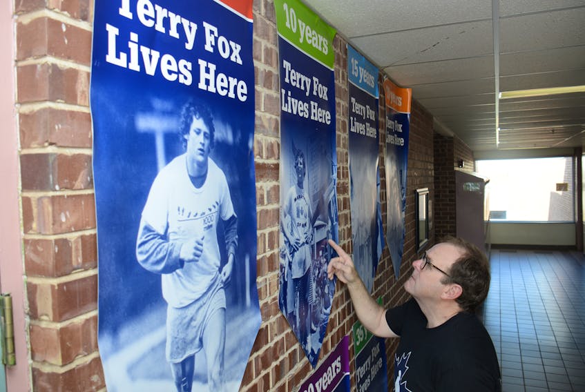 Gordie Cox looks at some of the posters on a wall dedicated to Terry Fox at Colonel Gray High School.