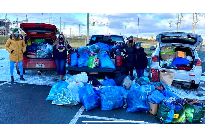 Jennifer Platts-Fanning, left, Carah Ross, Courtney Crosby and her son, Landon Richardson, stand in front of some of the donations they collected on Dec. 20 for Islanders experiencing homelessness. The group was inspired by the recent closure of a culvert in Charlottetown used as a shelter by unhoused people living with addictions.