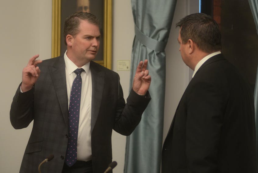 Bloyce Thompson, left, and Matthew MacKay are shown prior to a spring legislature session earlier this year. Four PC cabinet ministers, including Thompson and MacKay, are either dissolving or trusteeing companies in which they held stake prior to becoming members of the executive council.