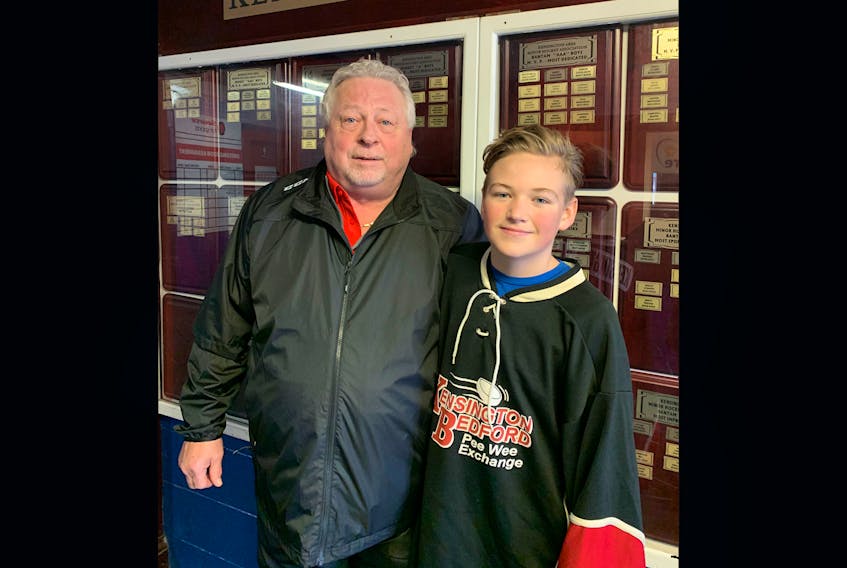 Bob Mann poses with his grandson, Ben Rogers, inside the main entrance at Credit Union Centre in Kensington. Mann played on the inaugural Kensington team to participate in the Kensington, P.E.I.-Bedford, Que., Peewee Friendship Hockey Exchange during the 1968-69 season. Ben is a left-winger on Kensington’s team this year. Bedford visits Kensington this weekend.