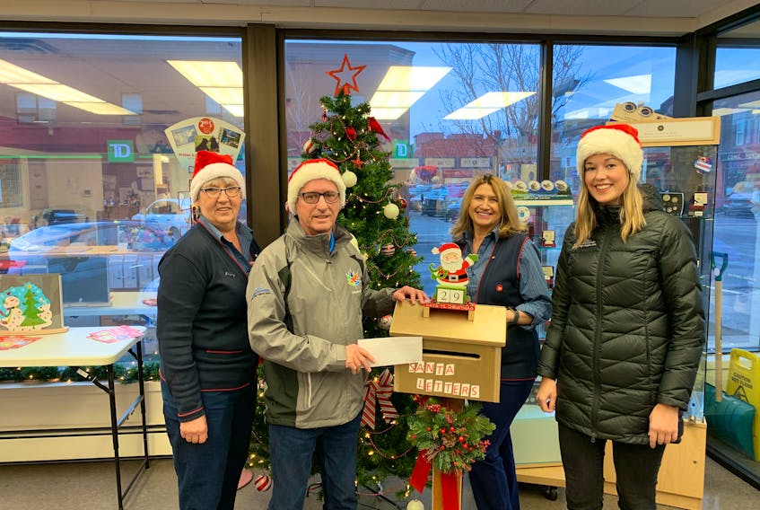 From left, Canada Post employee Wendy Dunn, along with the city’s events committee chairman Coun. Kevin Ramsay, Canada Post employee Pauline MacIntyre and tourism and events co-ordinator Charlotte Nicholson showcase the Santa letters mailbox at the downtown Canada Post office.