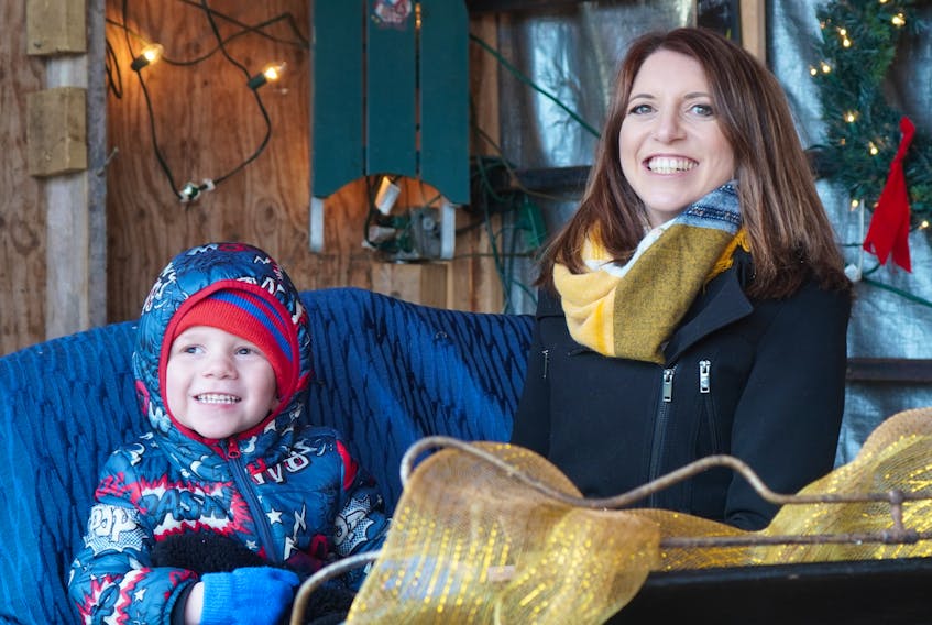 Verity Kislingbury and her three-year-old son, Jake, sit in Santa's sleigh at the Jenkins' farmhouse in Canoe Cove on Nov. 19. Jake was diagnosed with a rare cancer that left him blind in May 2020.