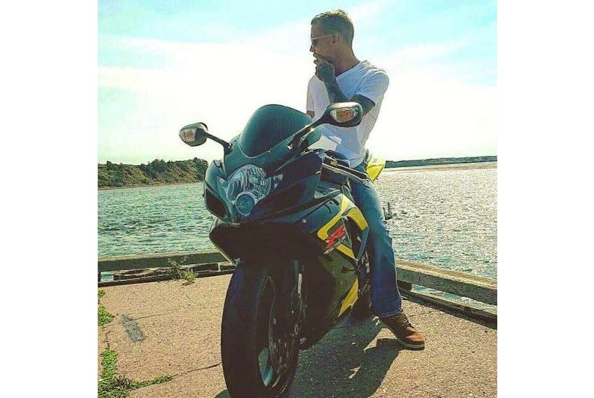 Cameron Gray parks his motorcycle to take in the sights at a P.E.I. wharf. Gray died in Aug. 2019 and is being remembered by his loved ones at a group drive across the Island Sept. 1. Ryan Donovan photo.