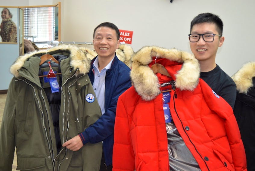 Paul Deng, left, and his son, Iverson, display two of the types of the Atlantic Canadian-branded Cyanos Jay winter jackets they are selling online and at their store at BDC Place on Kent Street in Charlottetown.