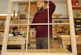 Octavio Salcedo of an architectural firm in Montreal that specializes in conservation, gave Holland College heritage retrofit carpentry students a workshop Wednesday to prepare them to work on the restoration of two large windows from Province House. Carpentry student Sebastian Saez listens to Salcedo's instructions.