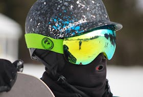 Jarvis Garro eyes the slopes of Mark Arendz Provincial Ski Park during a day of snowboarding on Dec. 28. Pictured in the reflection of his goggles is one of the park's main alpine routes, Front Lawn, as well as a reporter for The Guardian who forgot his winter boots.