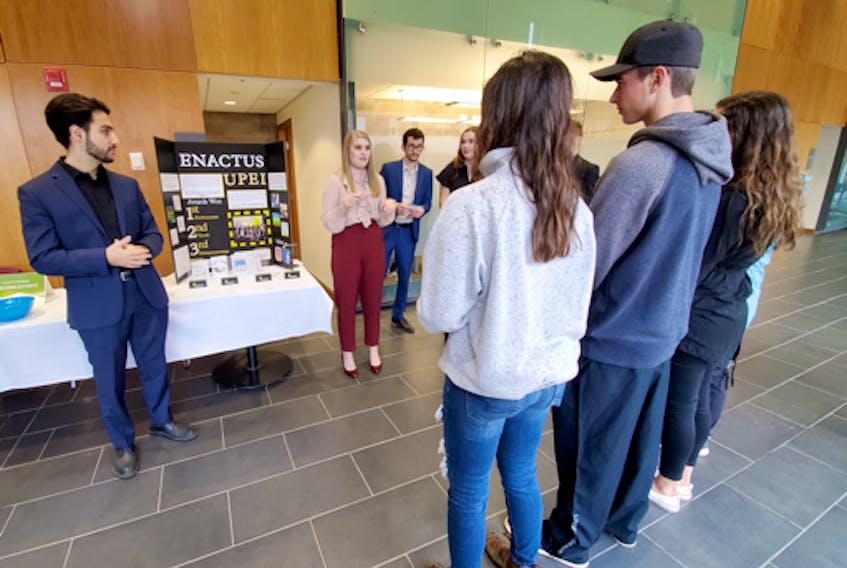 Enactus UPEI members Dan Timen and Ashley Doucette speak with a group of students at the UPEI open house in September 2019.