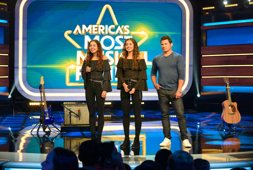 Lily Rashed, left, and her twin sister, Ava, are shown onstage during a performance on Nickelodeon’s “America’s Most Musical Family’’ in August. That performance will air on Friday, Dec. 6, at 8 p.m. (AST) on Nickelodeon and YTV in Canada. Thirty acts are taking part in in a competition where the prize is a recording contract and a chance at $250,000 in cash. Also pictured is the program’s host, television personality Nick Lachey.