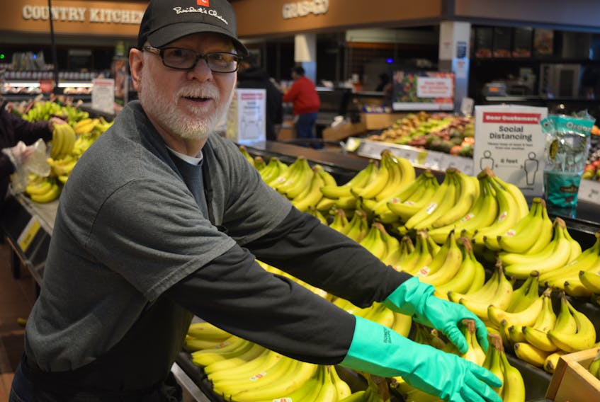 Gary Bowness, produce clerk at the Atlantic Superstore on University and Belvedere avenues in Charlottetown, stocks the shelves with bananas. The Superstore, like most of the big-box grocery stores, is looking to hire additional employees to keep up with the increasing demand.