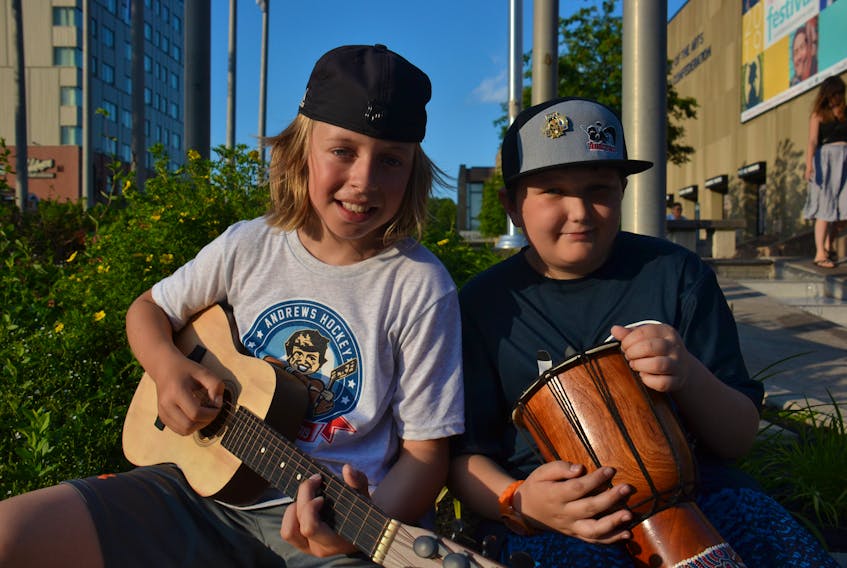 Cogan LeBlanc, left, and Colby Peters busk in Charlottetown to help those displaced by the Harley Street fire on July 17.