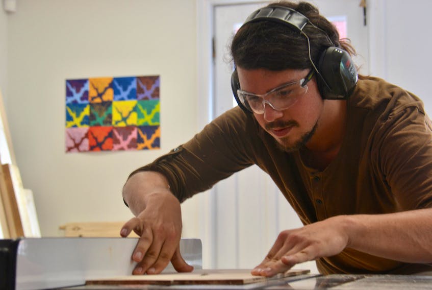 Brandon Hood, office manager of Nine Yards Studio, runs some wood through the buzz saw in their firm’s Secret Design Bunker. The office and bunker is located on the corner of Queen and Fitzroy Street in Charlottetown.