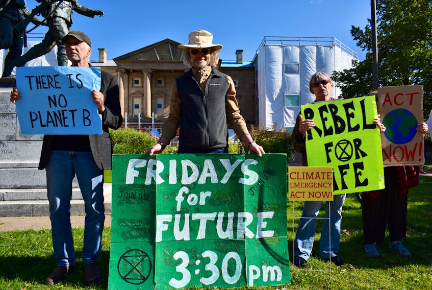 From left, Michael Pagét, Mike Antolick and Christine Gates stand in front of Province House at a weekly Fridays for Future solidarity protest organized by Extinction P.E.I. Fridays for Future is an international movement to support climate activist Greta Thunburg. Michael Robar/The Guardian