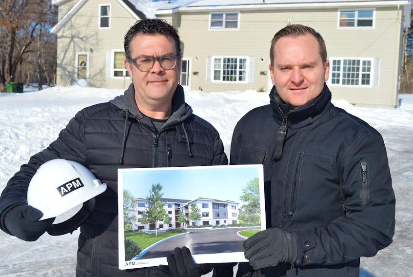 Cain Arsenault, with APM, poses with Trevor Bevan of Bevan Enterprises with a drawing of what the new 41-unit apartment building on Pine Drive in Charlottetown will look like in this file photo. Council approved the project Monday.