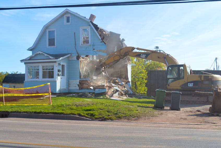 Heavy machinery tears down a house on Kensington Road.