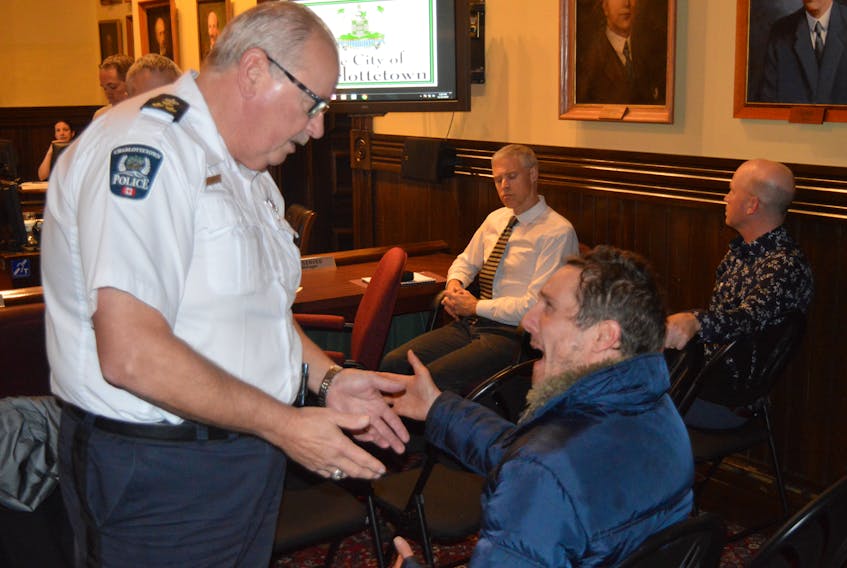 Charlottetown Police Chief Paul Smith, left, deals with climate protester Matthew Lepley during city council's regular monthly meeting on Tuesday night at City Hall.