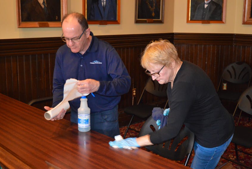 Paul Clow, left, and Pat Thompson, cleaners with the City of Charlottetown, were hard at work Monday morning giving all of the tables and chairs in council chambers a good wipe down.  Staff has also re-arranged the desks to create a bit more space between the councillors.