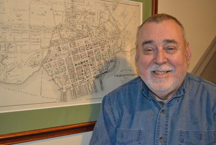Reg Porter of Belle River sits next to an 1880 Meacham Atlas map of the city of Charlottetown. Porter was recently honoured by the city with the Catherine G. Hennessey Award for his work in documenting and promoting the history of the capital.