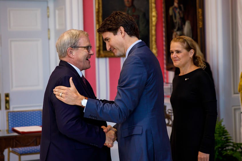 Prime Minister Justin Trudeau, centre, congratulations Cardigan MP Lawrence MacAulay during a swearing in ceremony in Ottawa on Wednesday as Governor General Julie Payette looks on. MacAulay was sworn in as minister of veterans affairs and associate minister of national defence.