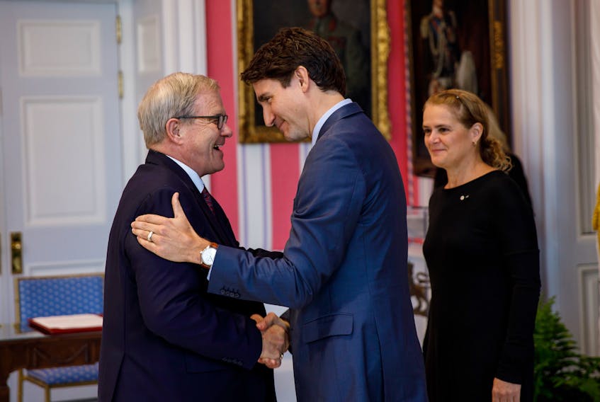 Prime Minister Justin Trudeau, centre, congratulations Cardigan MP Lawrence MacAulay during a swearing in ceremony in Ottawa on Wednesday as Governor General Julie Payette looks on. MacAulay was sworn in as minister of veterans affairs and associate minister of national defence.