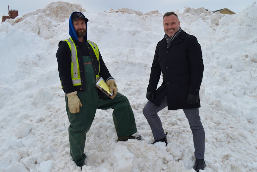 Pat Brunet, left, site manager, and Wayne Long, spokesman for Capital Events Inc., stand on a giant pile of snow that has been dumped in the Charlottetown Area Development Corporation parking lot next to Confederation Landing Park. Work has begun on the outdoor snow kingdom for the Jack Frost Winterfest, Feb. 14-17. - Dave Stewart